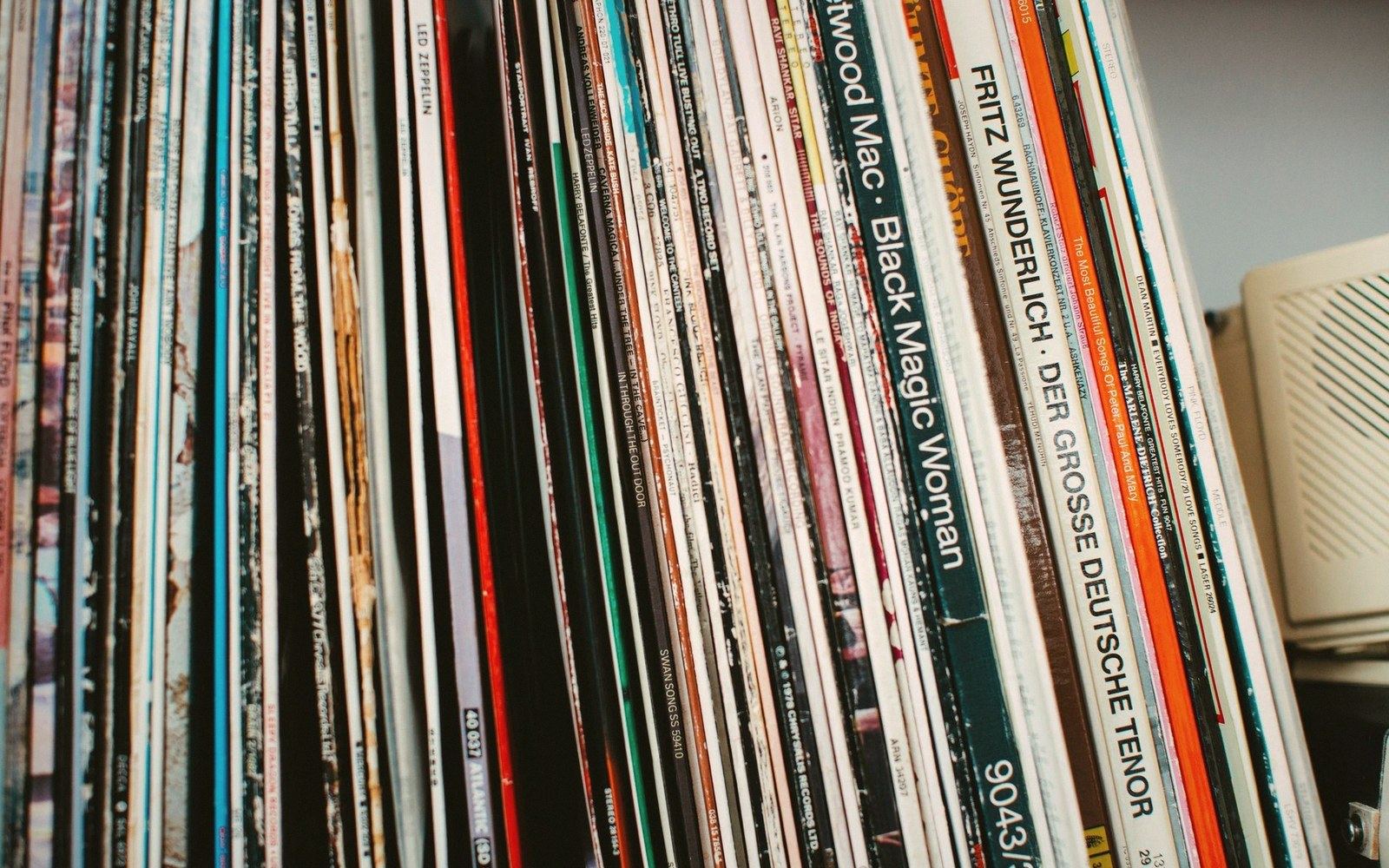 Vinyl record albums lined up on a shelf, spines showing titles like Fleetwood Mac